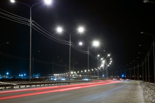 Night street with traces from light of headlights shined with street lanterns