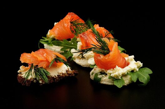 Appetizers Smoked salmon with dill on cracker isolated on black background