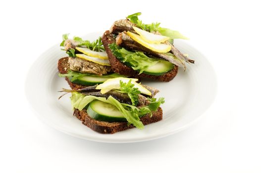 Smoked sardines sandwich with cucumber and whole wheat bread on white plate