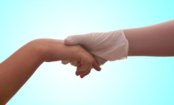 A hand with a medical latex glove holds another hand