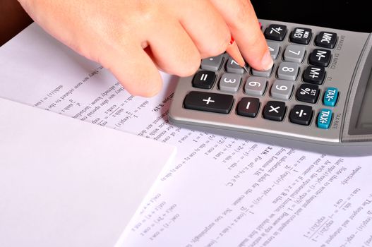 Student doing maths exercices with a calculator and a red pencil.