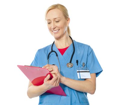 Portrait of happy senior doctor writing on clipboard isolated over white background