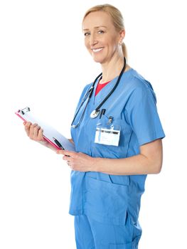 Experienced female doctor holding clipboard and carrying stethoscope around her neck