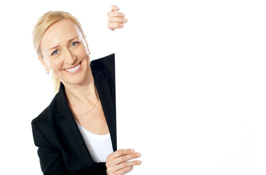 Smiling aged female executive holding clipboard, looking at you