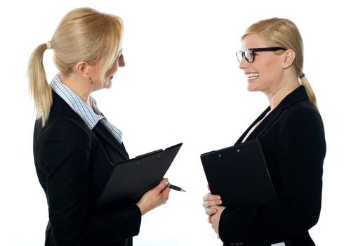 Corporate womans meet face to face, both holding documents