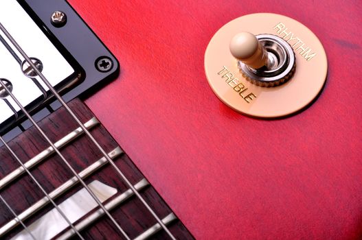 Closeup of a red electric guitar near the bridge