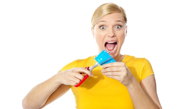 Excited female cutting her credit card isolated over white