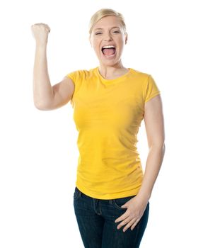 Fashionable teenager poisng with raised arms, shouting loud