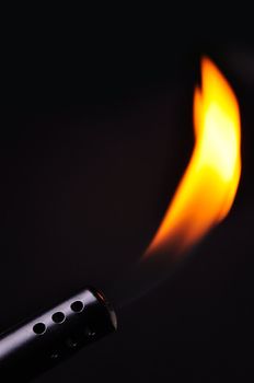 Closeup of a blow torche in a black background