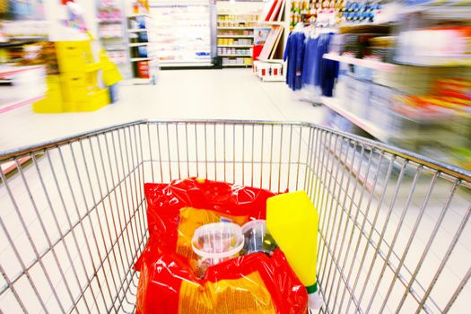 shopping cart standing between shelves in the supermarket