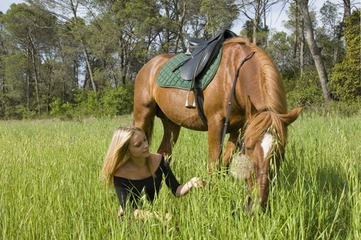 blond teenager and her brown horse in a field