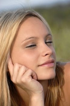 young blond teenager smiling in a garden