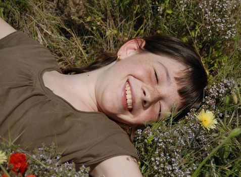 smiling girl laid down in a field with spring flowers
