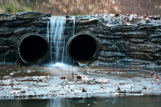 A small flowing waterfall between two pipes