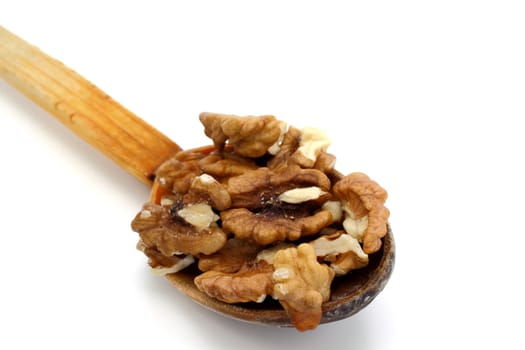 wooden spoon with walnuts over white background