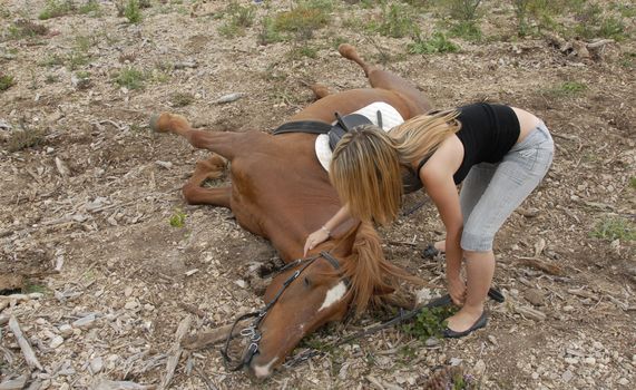 brown horse is falling with her riding teenager