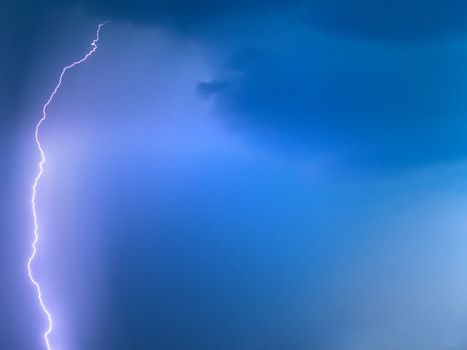 Lightling in blue sky while raining