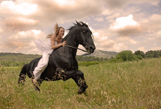 galloping beautiful wedding woman on her black stallion 