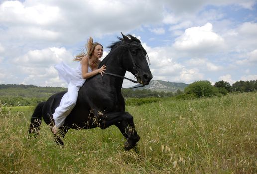 galloping beautiful wedding woman on her black stallion