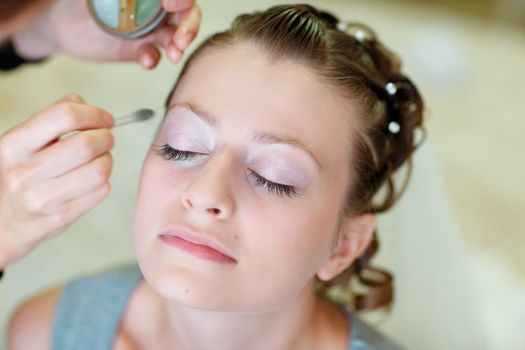 girl applying wedding make-up by professional make-up artist