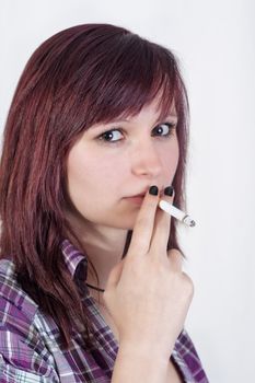 young redhead woman is smoking a cigarette - isolated on white background