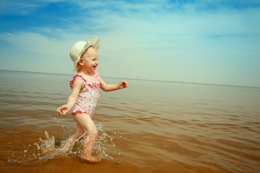 toned image -happy small girl running on the beach