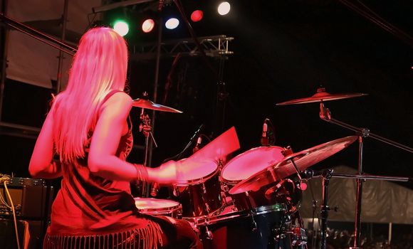 drummer girl  live on stage under red lights