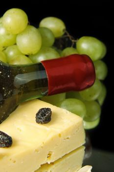Grape wine with cheese on black background