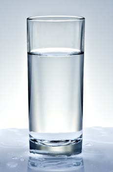 Glass of water on light background