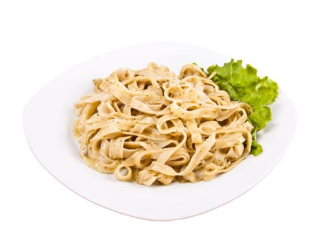 Tagliatelle pasta with pesto on white plate
