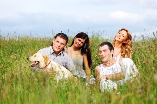 friends and dog in green grass field