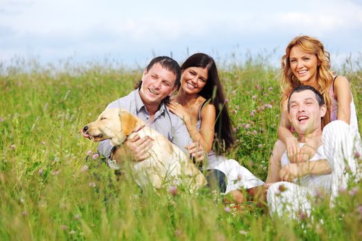 friends and dog in green grass field