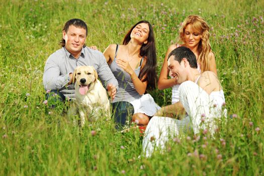 friends and dog in green grass field