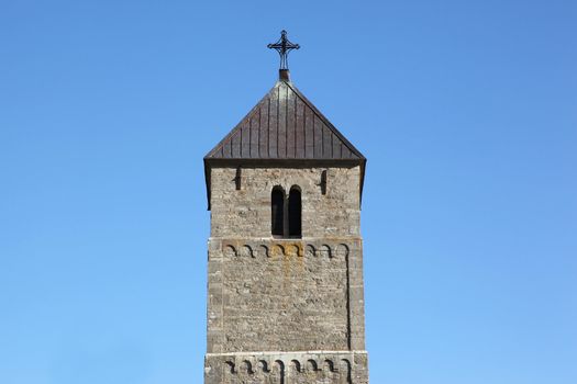 The upper part of a gothic tower towards a clear blue sky in Ostergotland, Sweden. With copy space around.