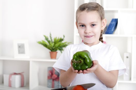 beautiful girl in the kitchen cooking vegetables