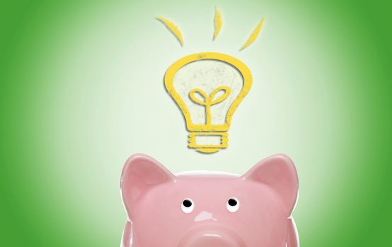 Piggy bank with idea light bulb on green background