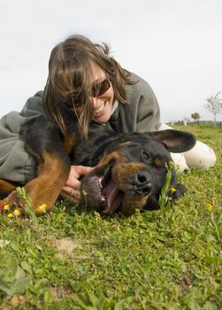 smiling young womand and her purebred rottweiler