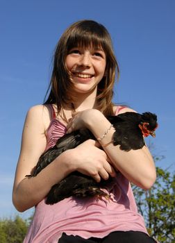 laughing girl and her little little black chicken in a farm