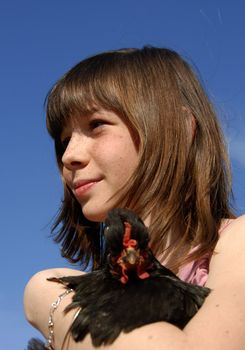 pensive girl and her little little black chicken in a farm (focus on the girl)