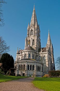 Saint Fin Barre's cathedral in Cork, Ireland (garden view and blue sky background)