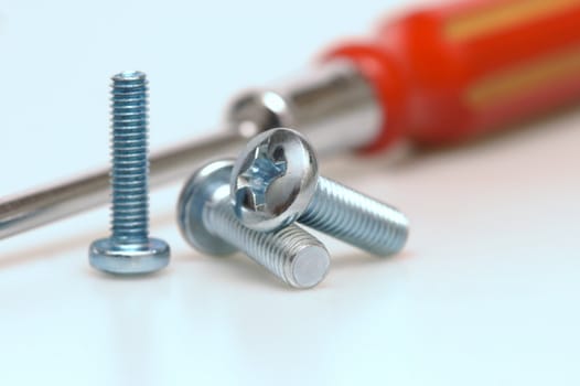 Great plan of three screws with a screwdriver background. shallow depth of field.