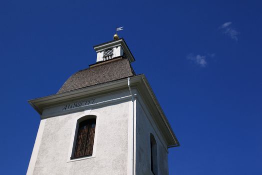 A white tower of a church built in late eighteenth century in Ostergotland, Sweden. 
