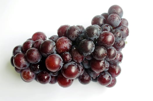 A cluster of ripe purple grapes on a white background
