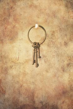 Set of three rusty keys in an open ring hanging freely, in grunge style.