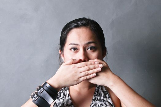 Young woman covering her mouth with both hands