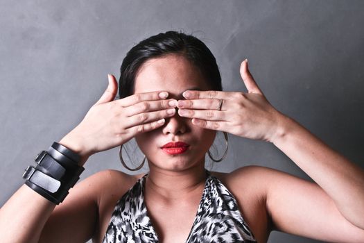 A young lady covering her eyes with both hands