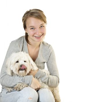 Pretty teenage girl holding adorable coton de tulear dog