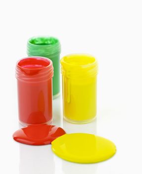 Open containers of paint in primary colors spilled and mixed