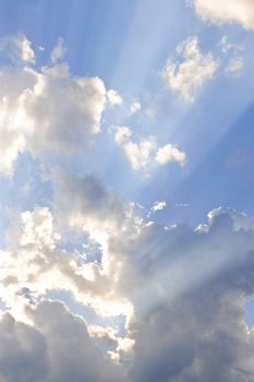 Background of blue sky with sun rays and clouds