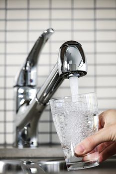 Filling glass of water from stainless steel kitchen faucet